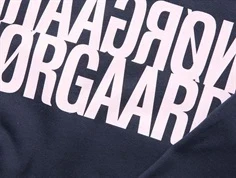 Detaljebillede af spejlvendt logo på Mads Nørgaard sweatshirt i parisian night